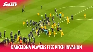 Moment Barcelona players flee pitch invaders after celebrating La Liga win