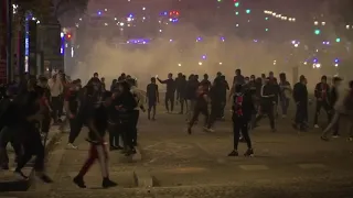 Baton wielding police patrol Paris as flare carrying PSG fans react after UCL defeat.