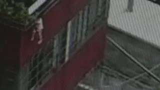 Toddler dangles by head from balcony in China