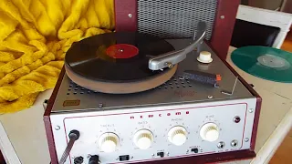 NEWCOMB TR-16 portable record player playing a 78 RPM record.