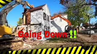 Two story two excavator home demo with the super stick and man is the neighbors  house close