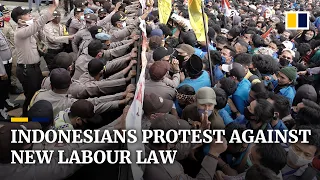 Indonesian police fire tear gas as thousands of people protest against new labour law