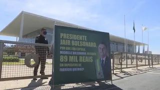 Manifestantes questionam depósitos de Queiroz com cartaz em frente ao Palácio do Planalto