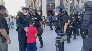 Tender moment caught on camera of police chief helping a young boy, who was scared at protest