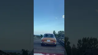 1970 Alfa Romeo 1750 GTV driving over a vintage wood bridge