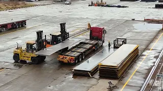 Loading steel plate on trailer by forklift.