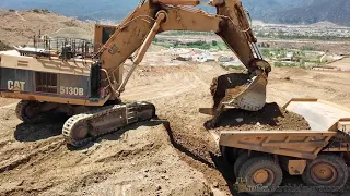 CATERPILLAR 5130B Excavator loading 777F Haul Trucks on large housing project