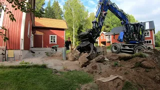 Bygger en stenmur med grävmaskin
