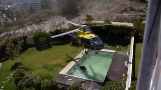 Amazing helicopter pilot taking water from swimming pool