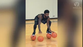 Kyrie Irving balances on two basketballs in training