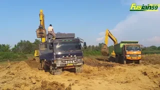 Excavator Digging Loading Dirt Into Dump Truck On Komatsu PC200