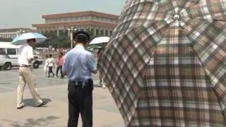 Police use umbrellas to stop filming on Tiananmen