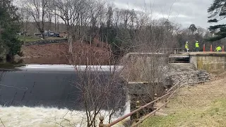 Crew works atop the Fitchville Dam in Bozrah after heavy rains caused the dam to partially fail