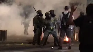 US riot police use tear gas and hit Portland protester with batons