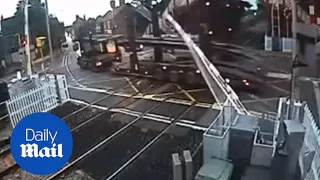 CCTV shows moment a lorry smashes through a railway crossing - Daily Mail