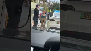 Woman trying to a Tesla up with fuel