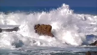 Relax - Strong crashing waves originating white foam against rocks and sand on the beach