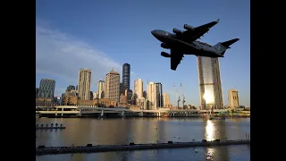 Military aircraft flying at low level over Brisbane river