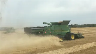 John Deere S790 combines combining wheat in Saskatchewan