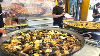 Cooking a BIG Spanish Paella with Seafood. Street food at Italian Food Fair