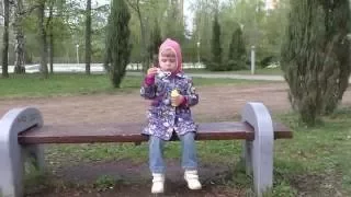 Девочка дует мыльные пузыри. Детская игра на свежем воздухе. Little girl blowing soap bubbles.