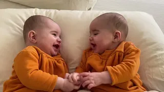 Twins talking to each other for the first time and holding hands