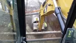 Cat 330d digging and laying 60" concrete drain pipe