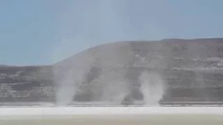 Multiple dust devils on a salt flat (salt devils?)