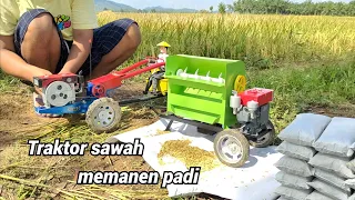 Traktor sawah menarik mesin perontok padi dan melewati jalan berlumpur