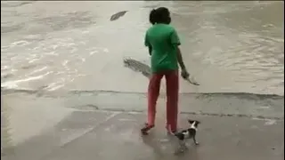 woman showed her slipper to the crocodile to scare.