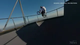 BMX star does tricks on bowl suspended under hot air balloon