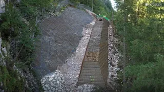 Geogrid reinforced rockfall protection dam