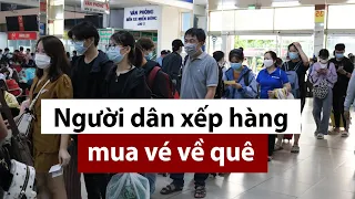 Người dân chen chúc xếp hàng mua vé về quê - PLO