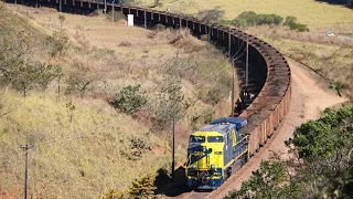 Longo trem de minério carregado com as locomotivas acelerando em força total, Ferrovia do Aço.