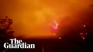 Firefighters and civilians drive through flames as wildfires rage through Spain