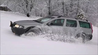 Volvo XC70 in deep snow. Volvo AWD. Winter drive uphill.