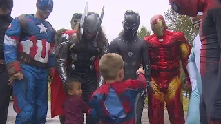 High school football players surprise birthday boy dressed as superheroes