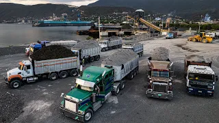 Trucks are unloading 7,500 tons of materials onto the barge.