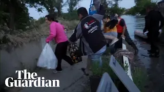 Shelling heard overhead as rescuers deploy boats to thousands at risk of floods in Kherson