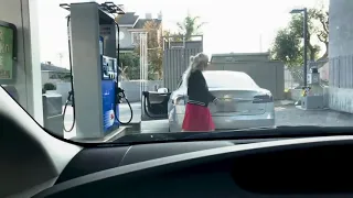 Blonde woman tries to fill Tesla tank with gas