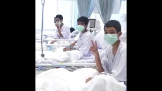 Rescued Thai boys make victory signs from hospital beds