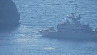 Hellenic Navy Roussen class Missile Boat maneuvering near rocky coast in Aegean Sea.