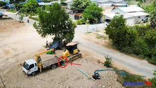 The car is stuck help with Bulldozer KOMATSU DR51PX pushing massive soil stone in the water