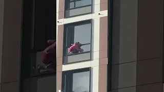Женщина в Астане моет окно на 17 этаже