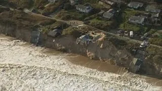 Worst tidal surge in 60 years batters UK east coast and drags homes into the sea