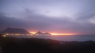 Iconic Table Mountain in sunset and city lights. From Cape Beach House Live webcam. Watch live