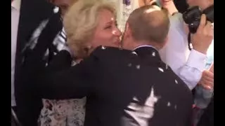 PUTIN SPEAKS ENGLISH: A lucky woman gives a kiss on the cheek to Putin in the centre of Mo