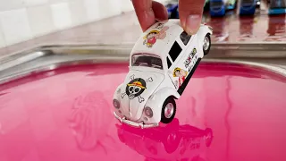 Diecast Cars Sliding Into The Pink Water