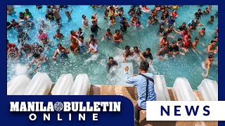 Pool attendants dump blocks of ice at a pool in Bulacan Province