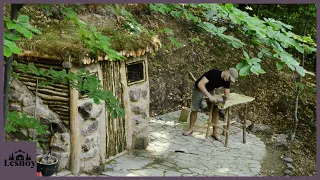 Shelter for survival in the forest. Construction of a house near a stream